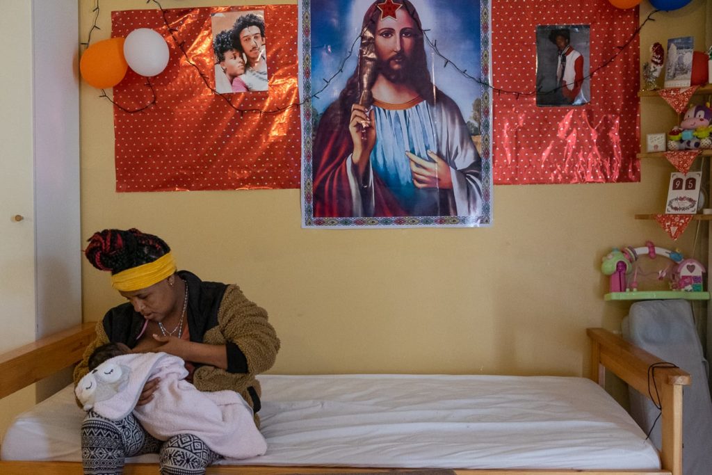 Femme donnant le sein à son enfant dans une chambre